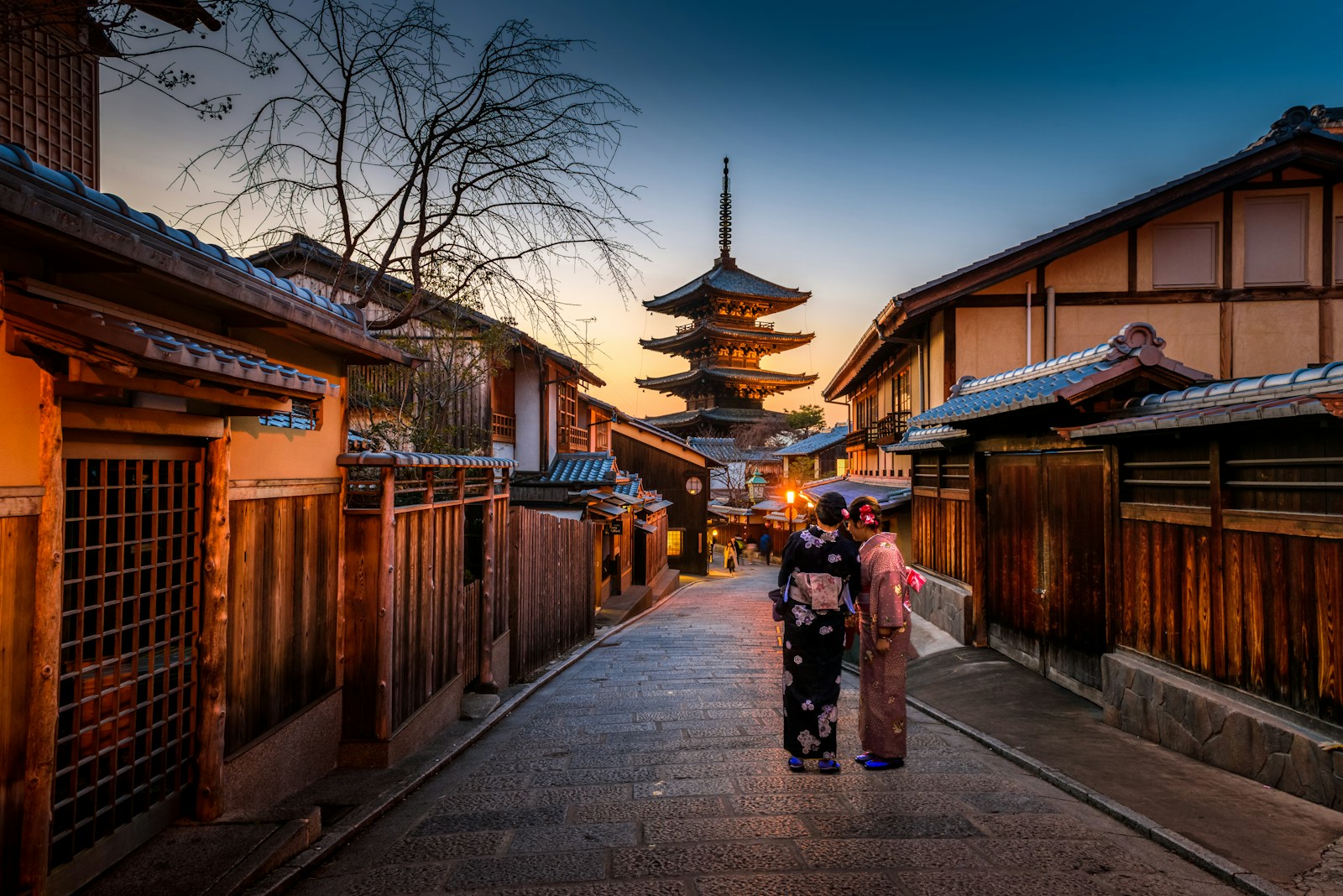 暮色中传统街巷、木屋与远处的塔